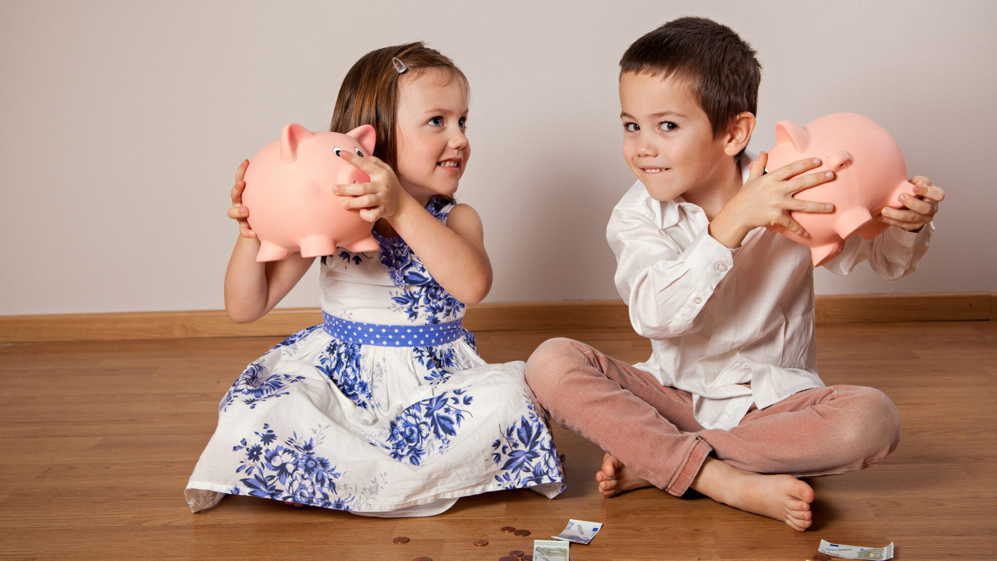 Duas crianças com porquinhos mealheiros – educação financeira