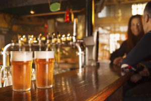 Couple on a date in pub, enjoying in beer. The grain and texture added. Very shallow DOF .